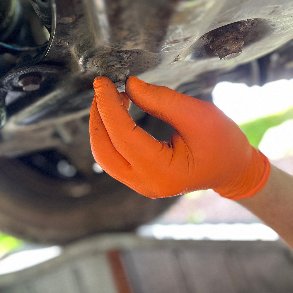 Einweghandschuh Nitril, Diamond, 0,25 mm, 50 St. »Nitril XTRA Grip Orange« orange, Anwendungsbild beim Auto.