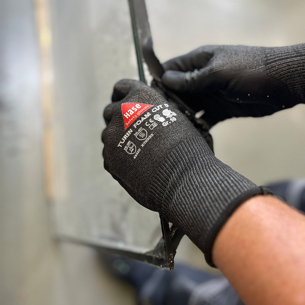 Schnittschutzhandschuh aus 15G HPPE, Nitrilschaum, CUT D »Turin Foam Cut D« schwarz, Anwendungsbild während Metallarbeiten.