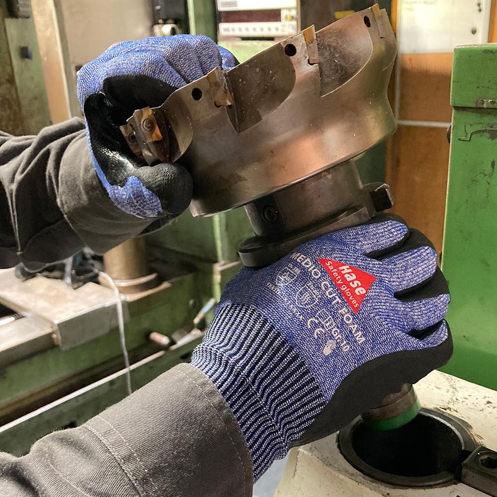 Schnittschutzhandschuh aus 13G HPPE, Nitrilschaum, CUT D »Medio Cut Foam« blau schwarz, Anwendungsbild bei Metallarbeiten.
