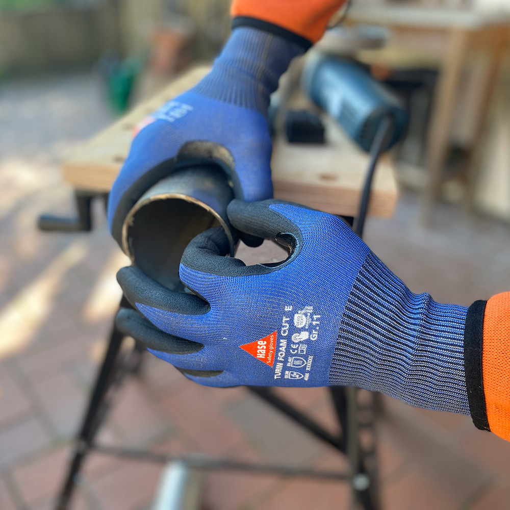 Schnittschutzhandschuh aus 15G HPPE, Nitrilschaum, CUT E »Turin Foam Cut E« blau schwarz, Anwendungsbild bei Metallarbeiten.