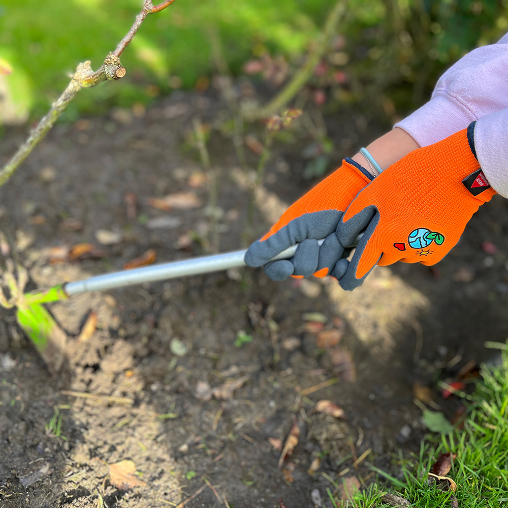 Kinderhandschuh aus 15G Polyester, Latexschaum, Kat I »KIDS 5« orange schwarz, Anwendungsbild im Garten.