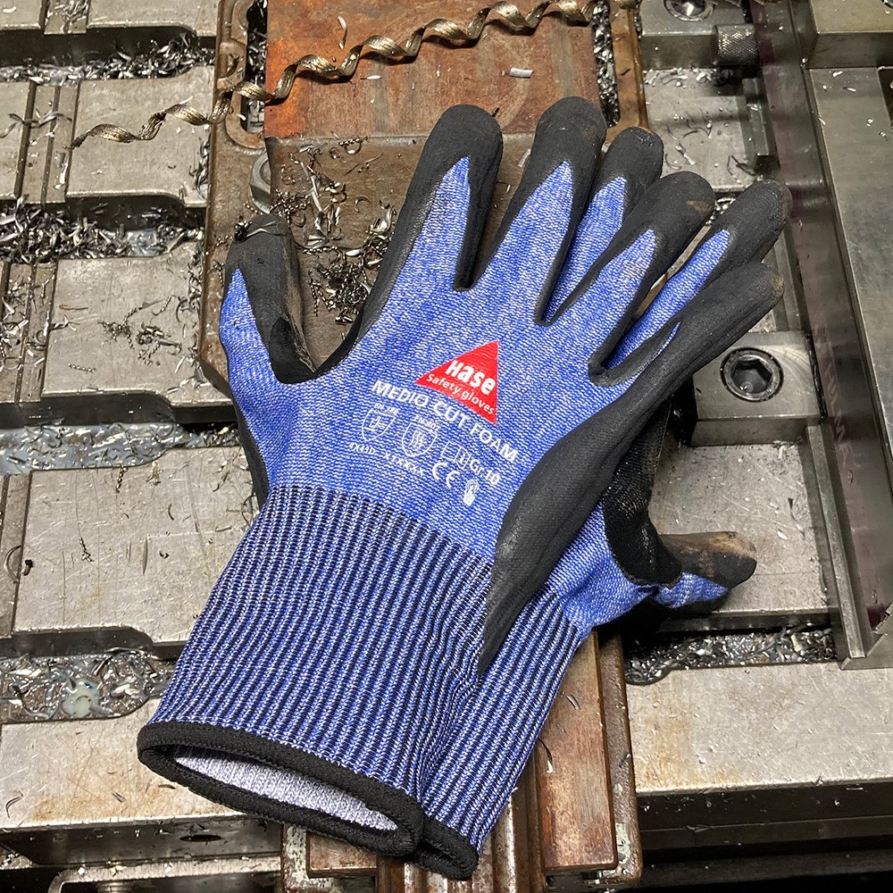 Schnittschutzhandschuh aus 13G HPPE, Nitrilschaum, CUT D »Medio Cut Foam« blau schwarz, auf Metall.