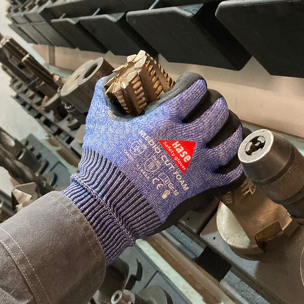 Schnittschutzhandschuh aus 13G HPPE, Nitrilschaum, CUT D »Medio Cut Foam« blau schwarz, Anwendungsbild in Werkstatt.
